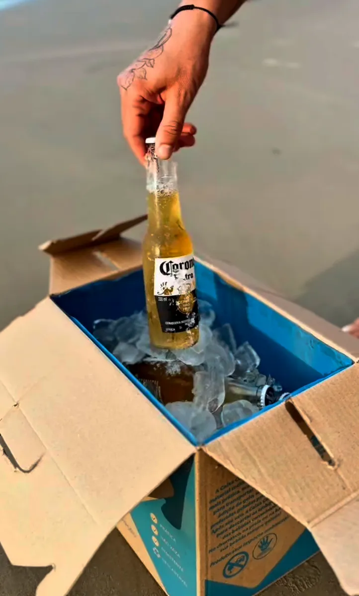 Cerveja gelada saindo da Caixa Cooler na praia